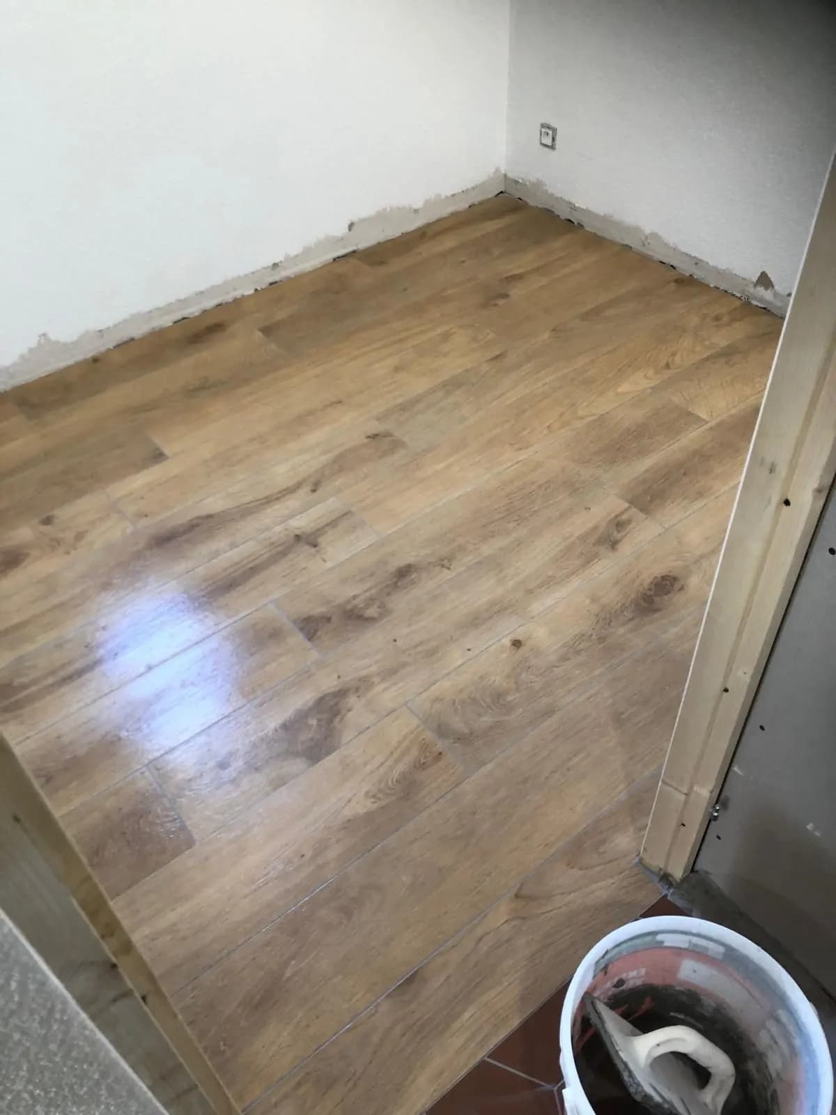 Sol en carrelage imitation chêne posé dans une chambre