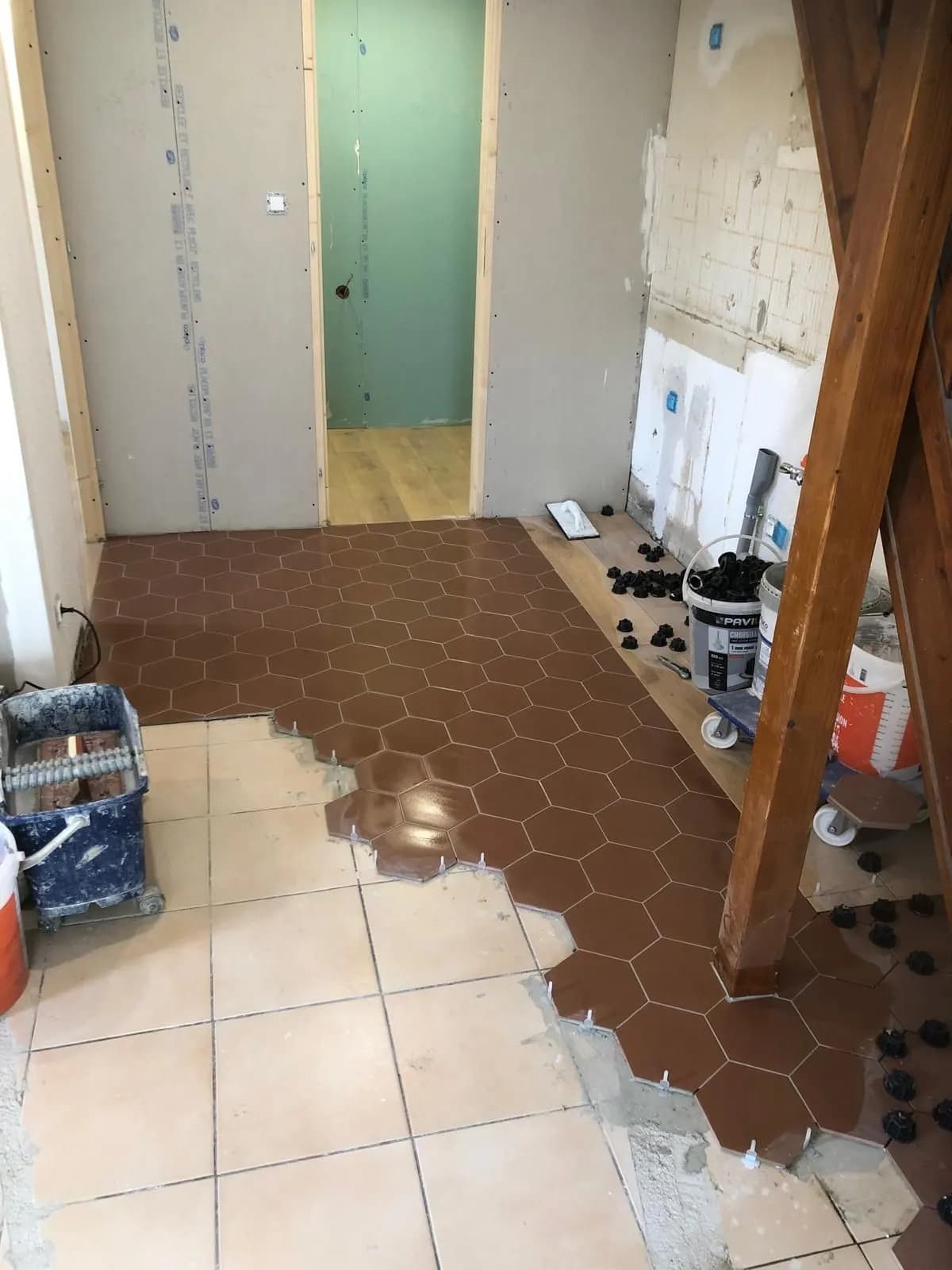 Pose de tomettes hexagonales brunes sur l’ancien carrelage