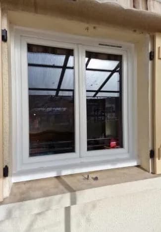 Fenêtre blanche à deux vantaux avec volets
