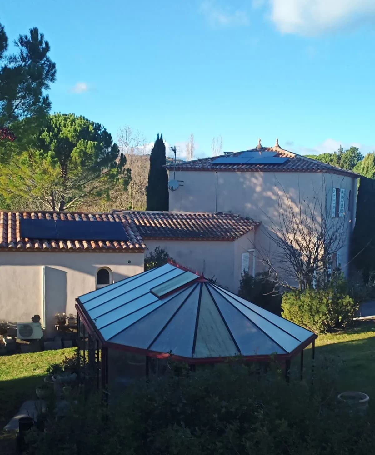 Panneaux photovoltaïques sur l’annexe et sur la tour d’une villa, véranda au premier plan