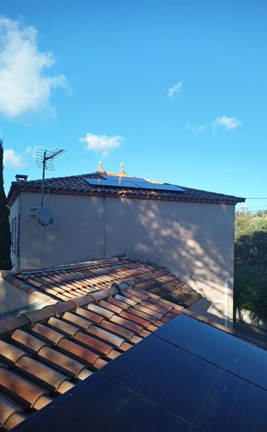 Panneaux photovoltaïques sur deux toitures, tour en arrière-plan