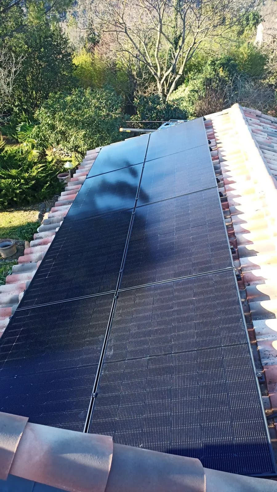Rangée de dix panneaux photovoltaïques sur tuiles, vue plongeante