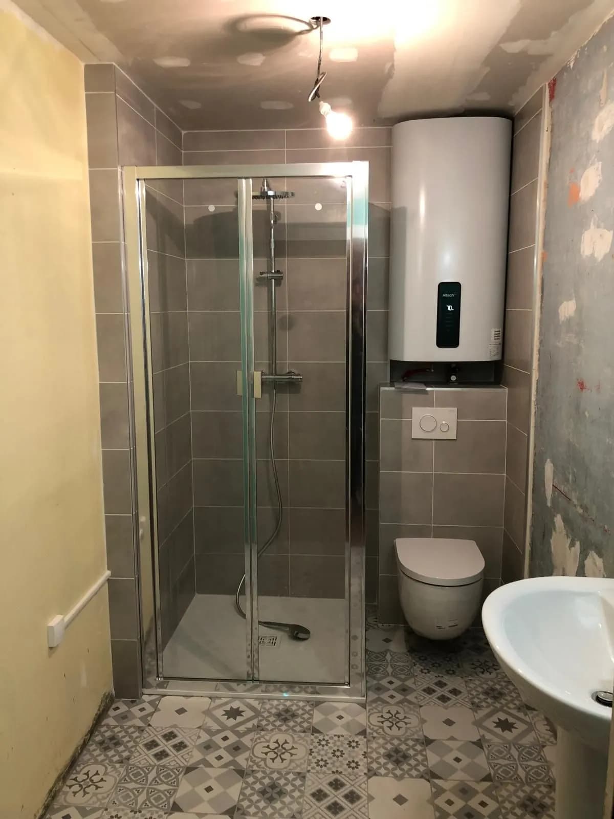 Douche à portes pliantes, ballon d’eau chaude et WC suspendu en cours de chantier