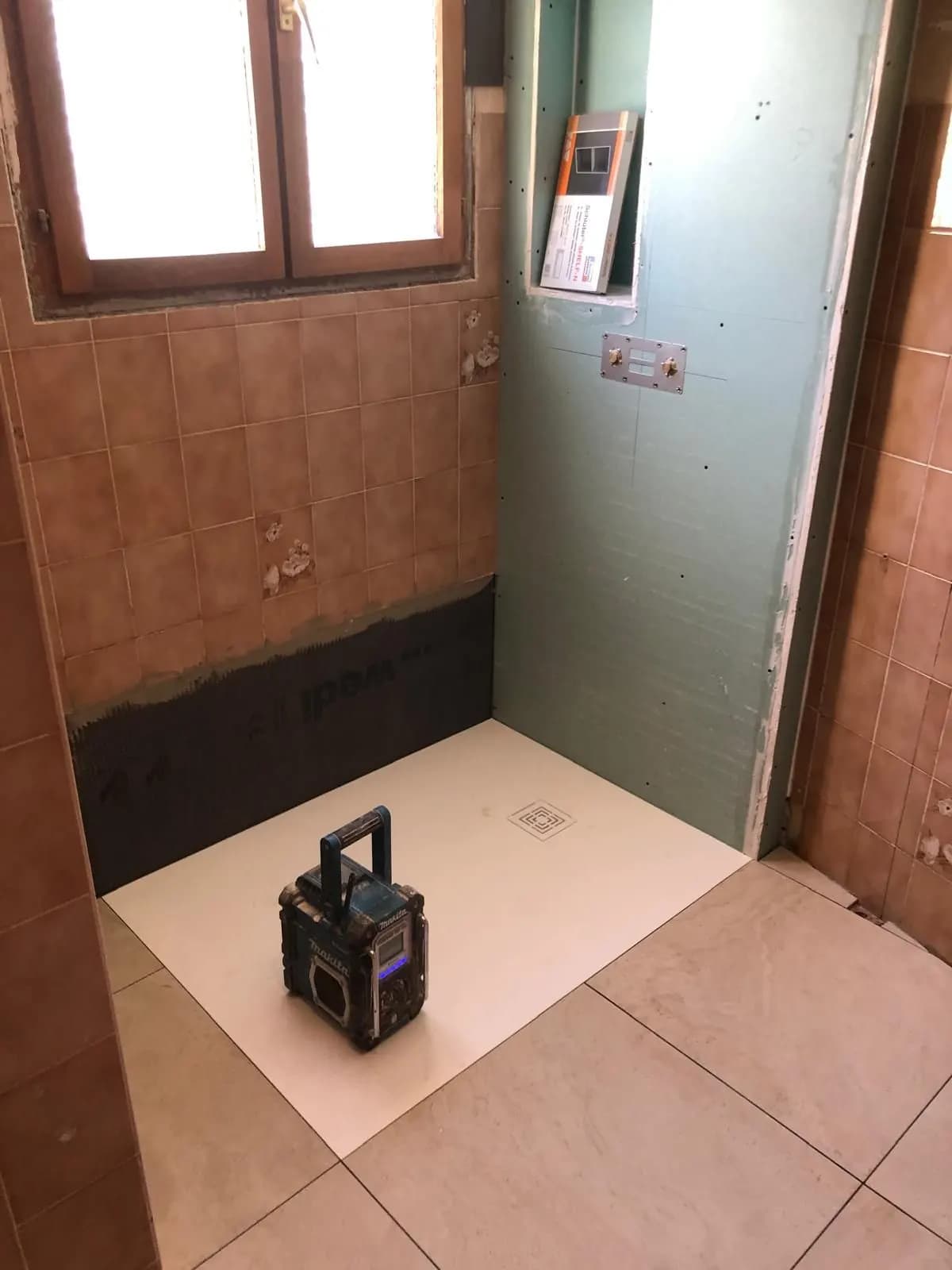 Receveur posé, plaques et niche en cours de pose dans une salle de bain