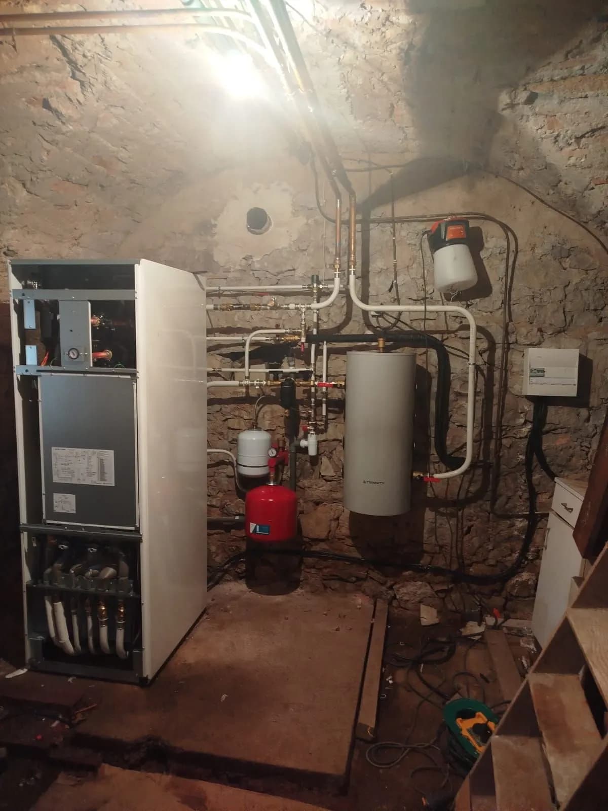 Module de pompe à chaleur ouvert pendant l’installation, dans une cave voûtée