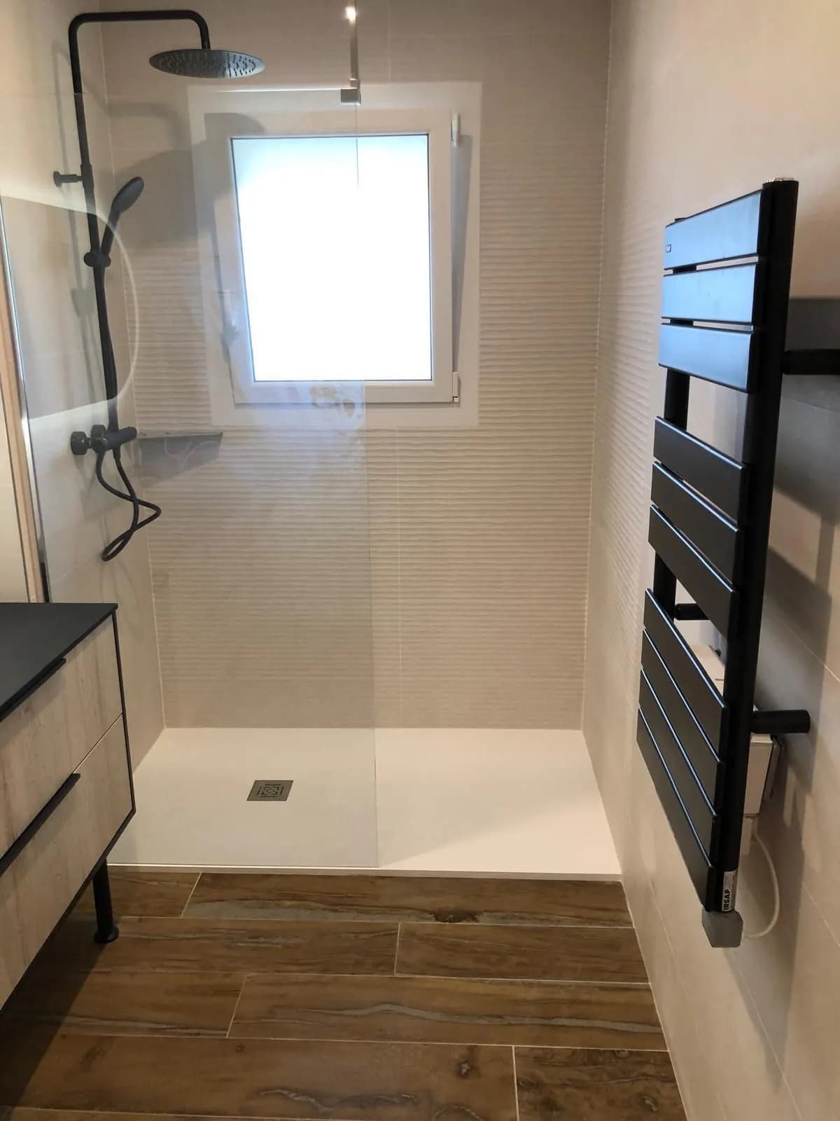 Douche à l’italienne, robinetterie noire, receveur blanc et sèche-serviettes noir