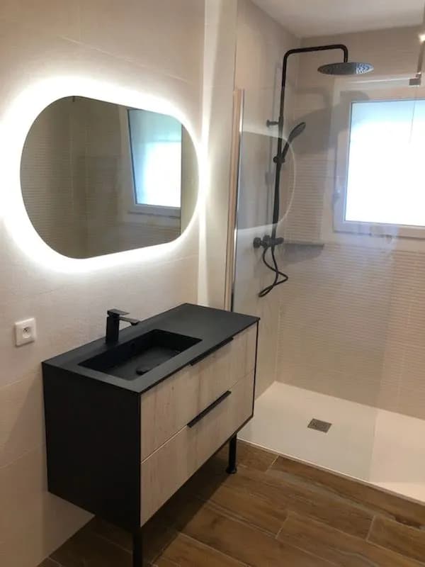 Meuble vasque noir et bois, miroir ovale à LED et colonne de douche noire