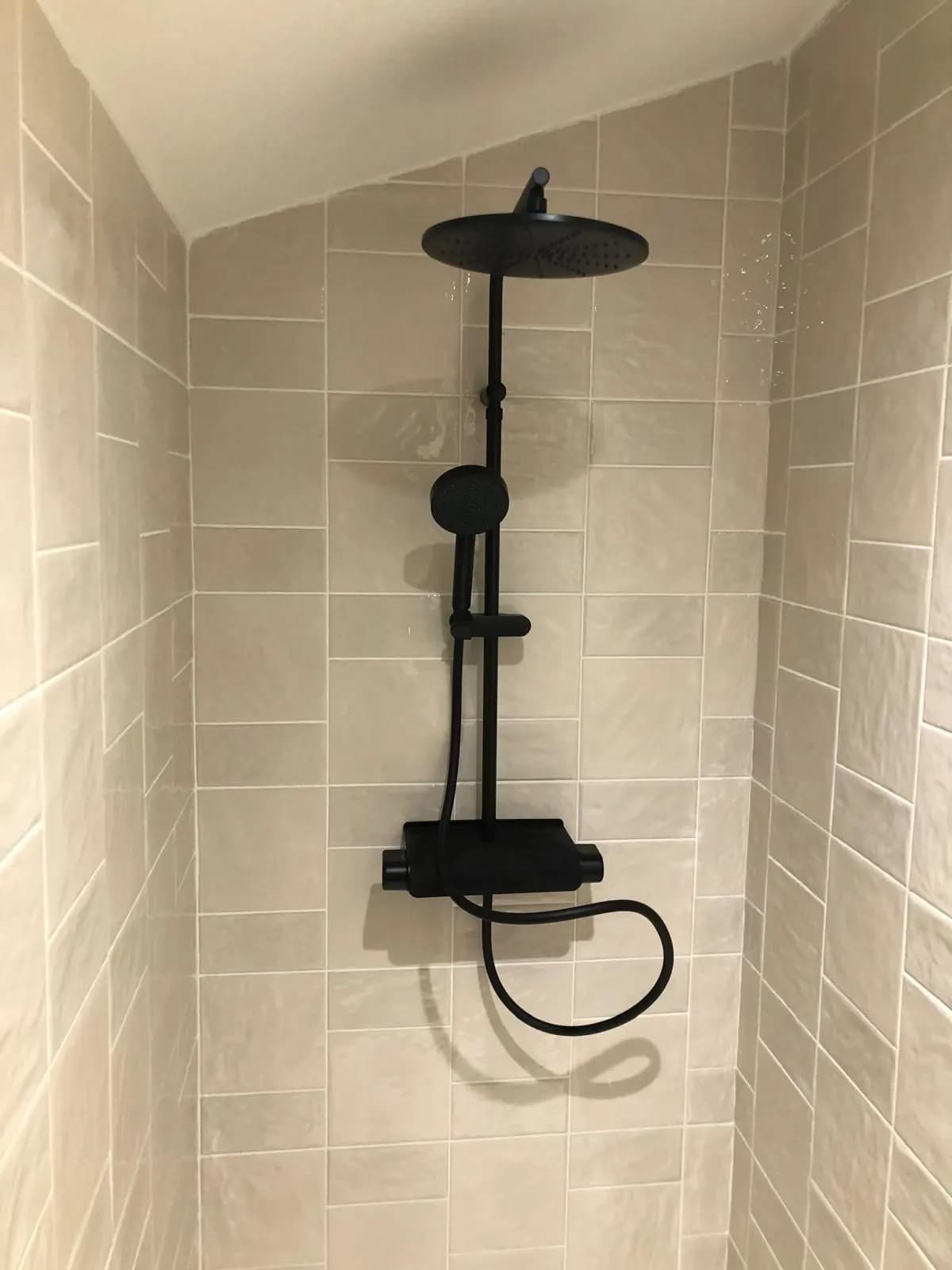 Colonne de douche noire mate sur faïence beige effet zellige