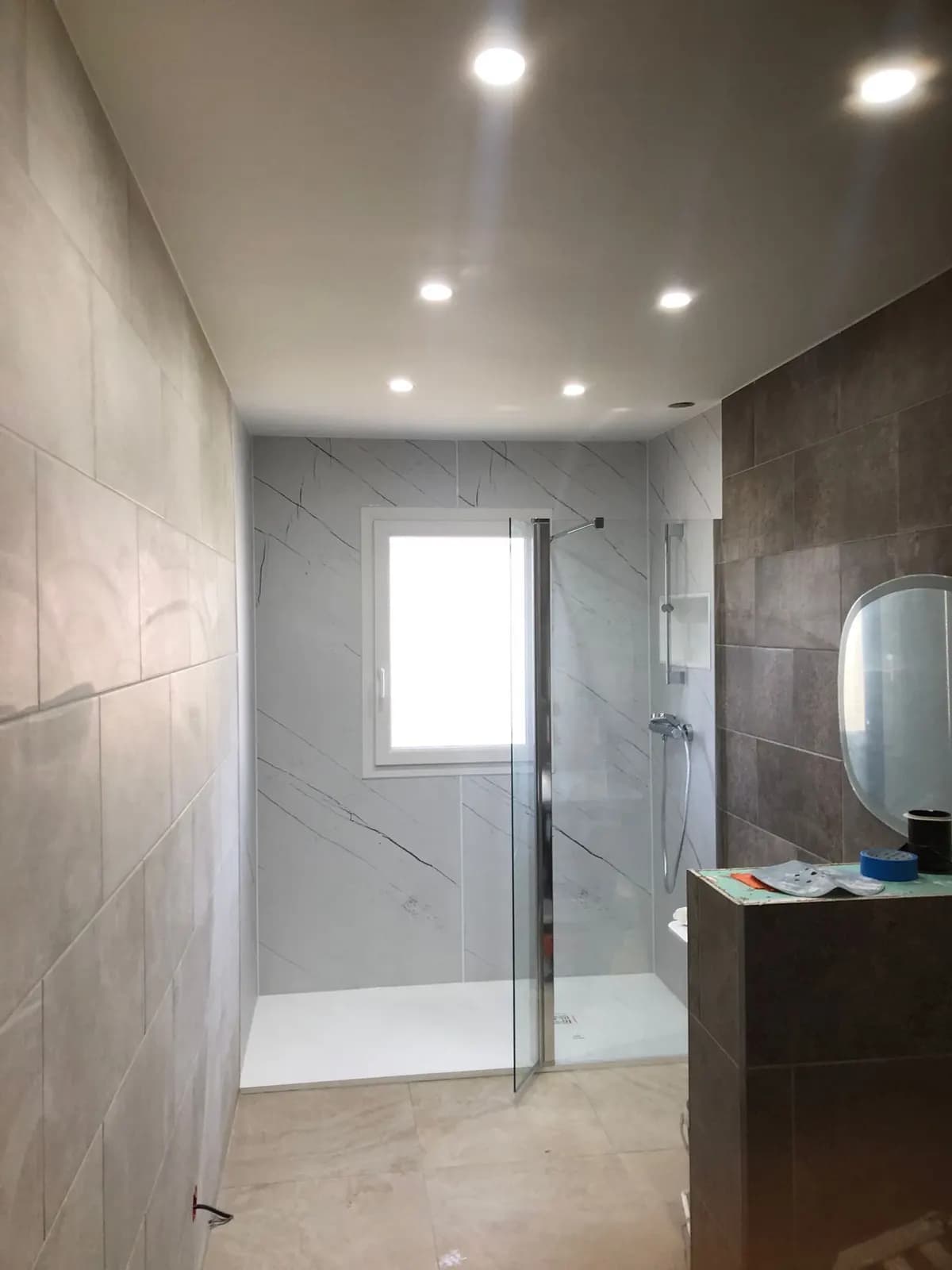 Grand receveur de douche et mur effet marbre, chantier en cours de finition