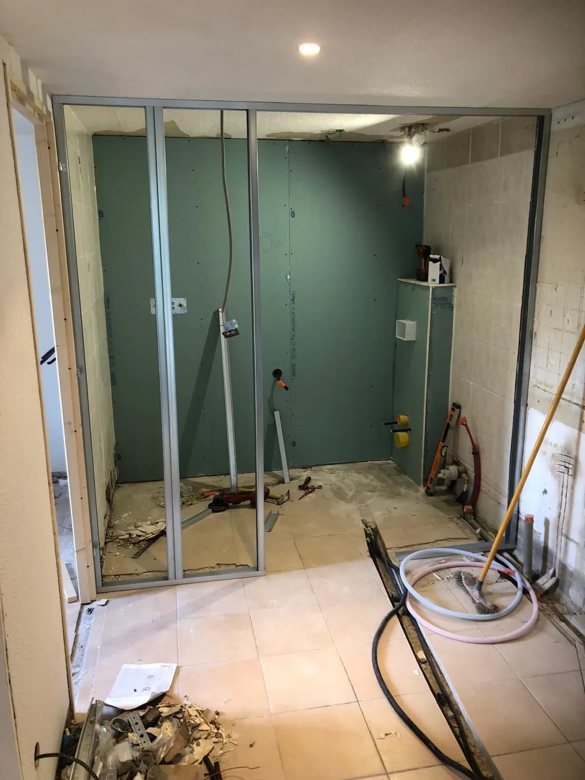 Chantier en cours : ossature métallique et plaques hydrofuges d’une salle de bain
