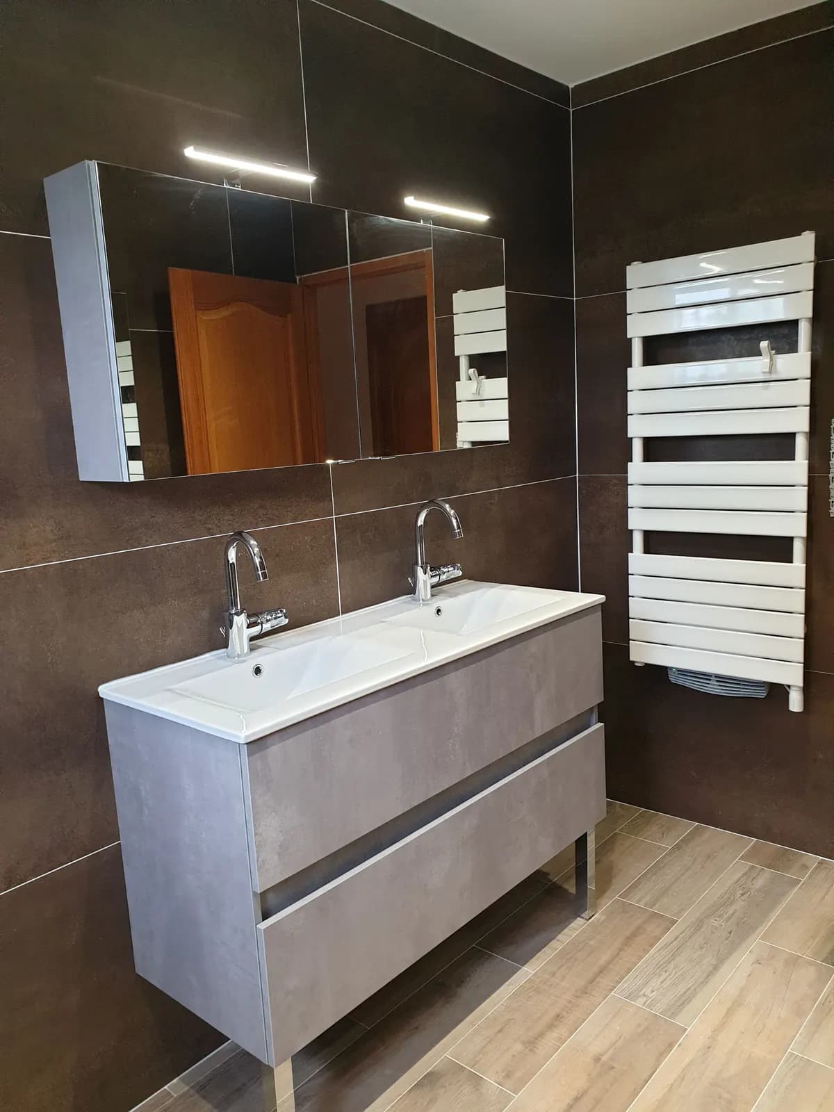 Double vasque sur meuble gris, armoire miroir à LED et sèche-serviettes blanc