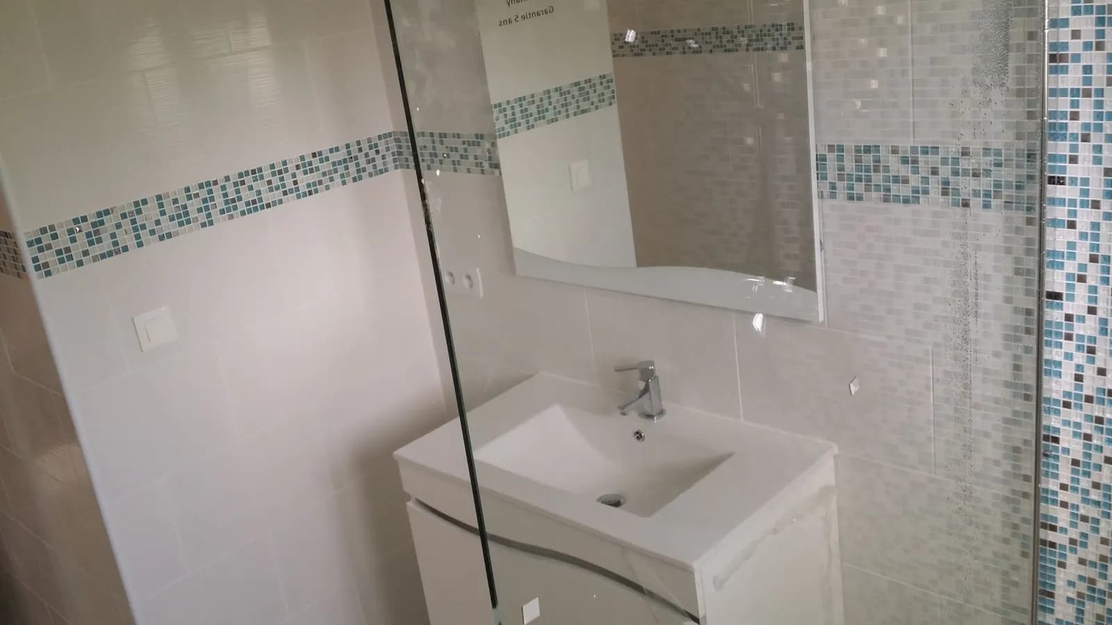Meuble vasque blanc, miroir et frise de mosaïque turquoise