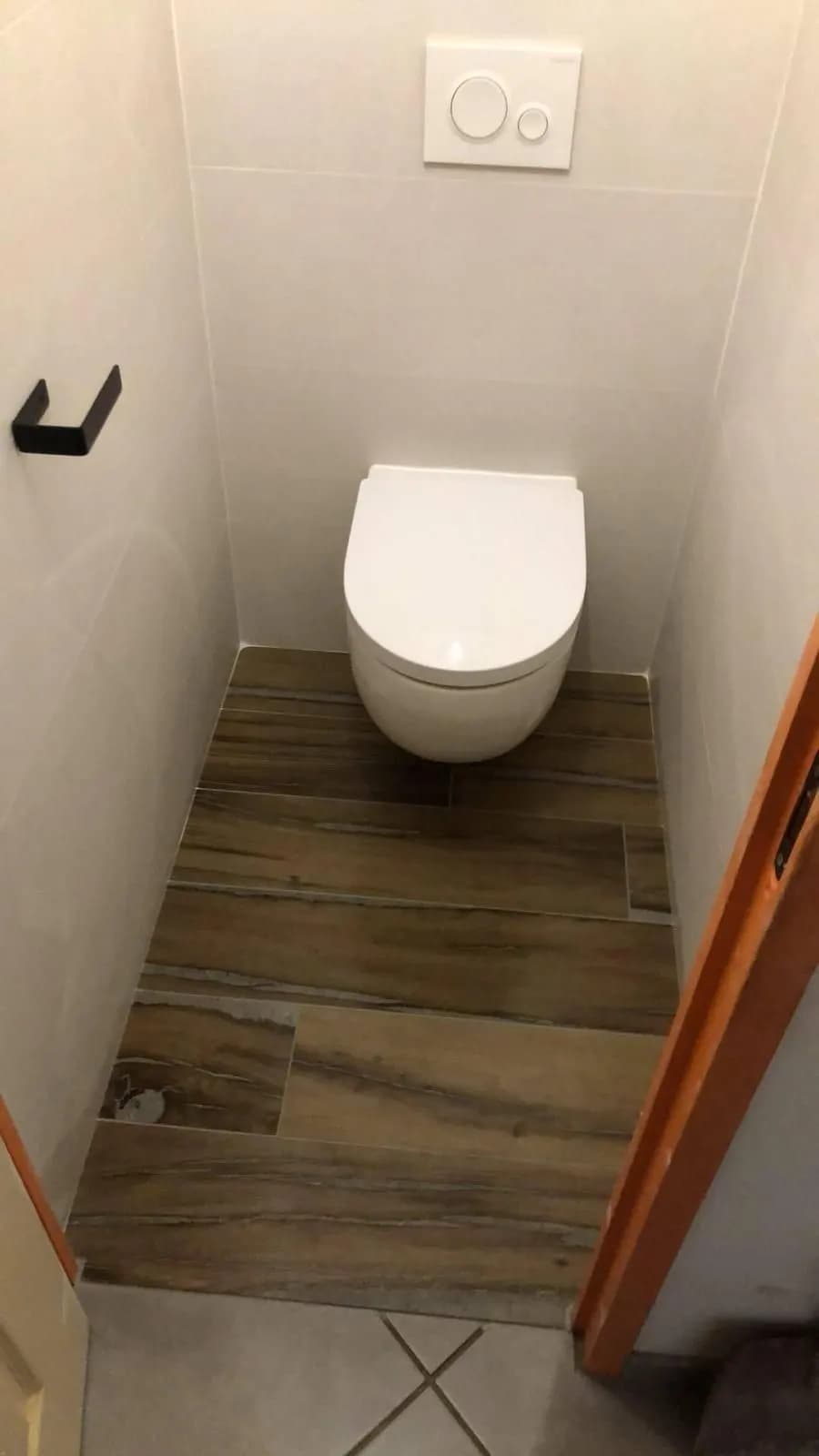 WC suspendu avec plaque de commande dans des toilettes étroites