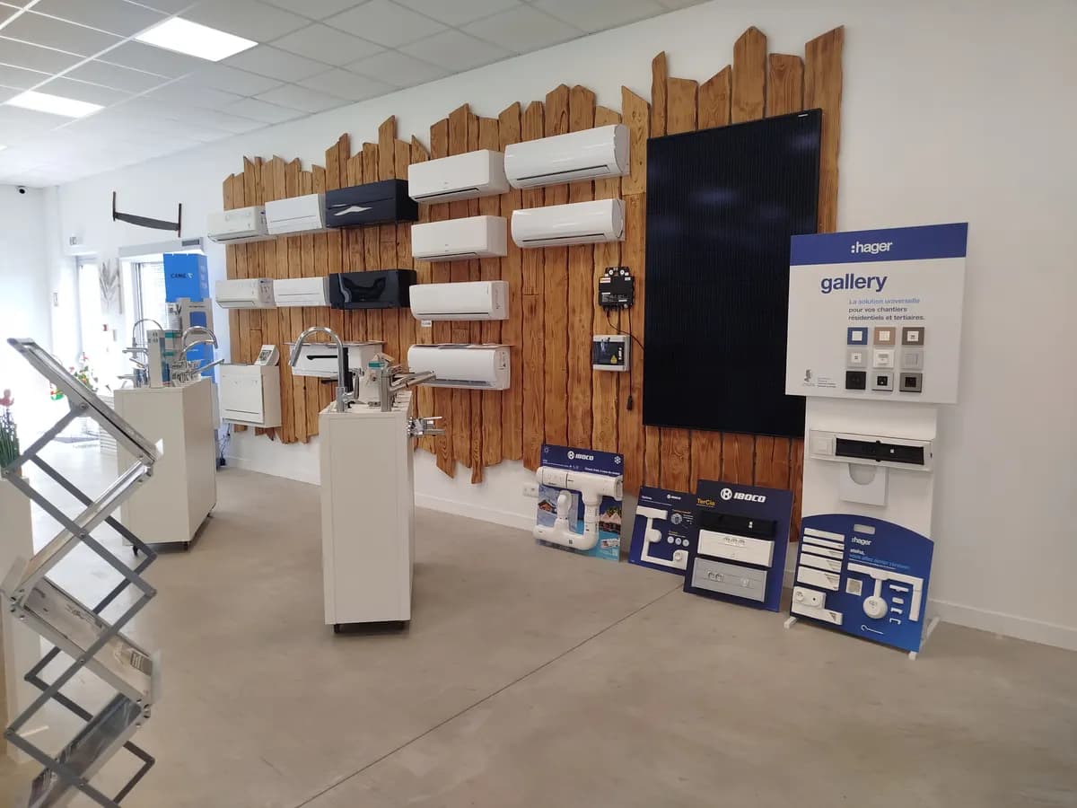 Mur d’exposition du showroom : climatisations, panneau photovoltaïque et appareillage électrique sur un mur en bois